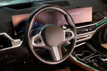Closeup of a modern car steering wheel with control buttons for technology and convenience