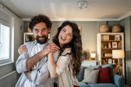 Happy couple embracing and laughing in their modern apartment