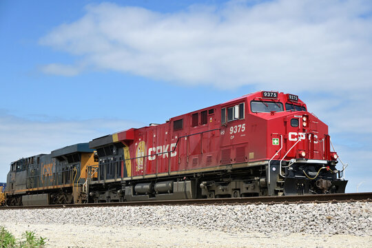 A Canadian Pacific Kansas City locomotive leads a container train as it approaches a local rail yard. The lead locomotive was the first unit to receive the new CPKC paint scheme.