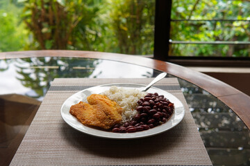 Breaded tilapia fillet with rice and beans, a healthy dish