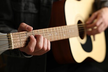 Obraz premium Man playing guitar on black background, closeup