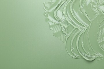 Collagen gel on green background, above view. Space for text
