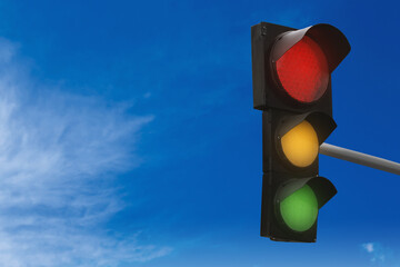 Traffic lights against blue sky with clouds