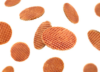 Yummy Dutch waffles (stroopwafels) flying on white background