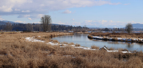 Winter panorama with river and grassy fields