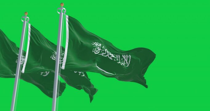 Saudi Arabian flags waving in the wind isolated on green background