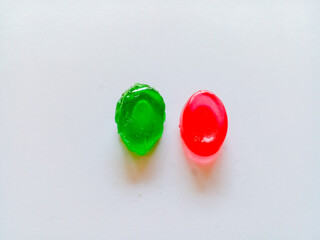 Green and red oval candy isolated on white background.
