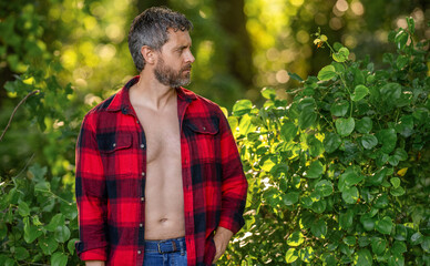 Lumberjack axe. Man with logging axe. Brutal man in unbuttoned shirt. Lumberjack hardworking...