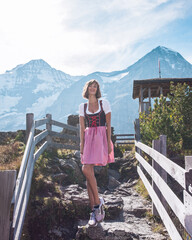 Beautiful young woman wearing traditional Bavarian clothes - dirndl or tracht standing and happy...