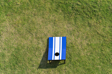 Cornhole game set on green grass. Aerial high angle view