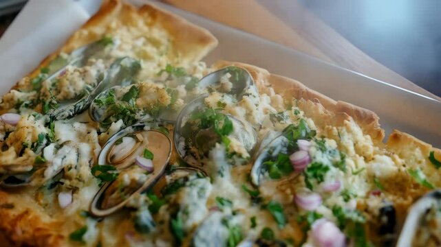 Delicious rectangular seafood flatbread pizza featuring fresh clams, herbs, cream sauce, and shallots as toppings