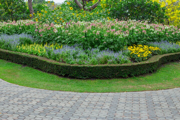 A public park with a variety of flower gardens along the walkway.