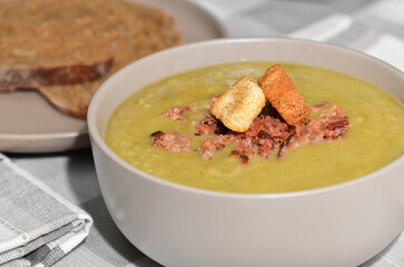 Split pea soup topped with bacon and a side of sliced bread
