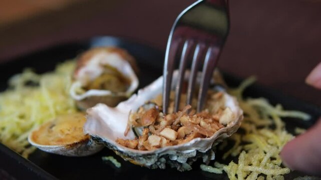 Baked stuffed fresh mussels in shell. to take food out of a shell with a fork. Baked stuffed clams