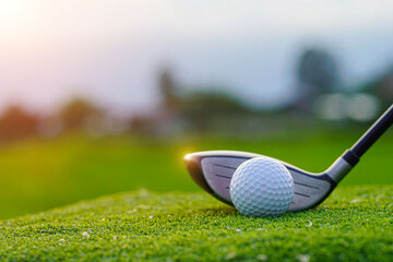 Golf clubs and golf balls on a green lawn in a beautiful golf course with morning sunshine.