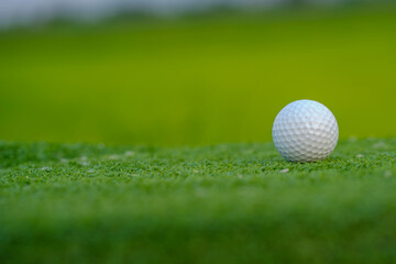 Golf balls on a green lawn in a beautiful golf course with morning sunshine.