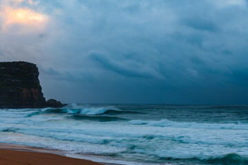 Moody sunrise with waves at the seaside