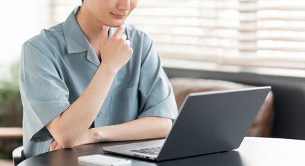 若い日本人男性がノートパソコンの画面を見ている。