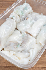 angle view box of traditonal Cantonese food of beef cheong fun or rice noodle rolls or steamed vermicelli rolls vertical composition
