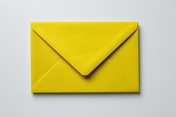 Vibrant yellow envelope rests on clean white surface, symbolizing communication and creativity