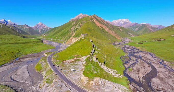 Aerial view of the curved river and green grassland with mountain natural landscape in Xinjiang. Beautiful scenery along the Duku Highway in China.