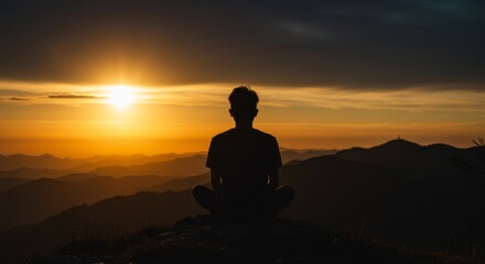Silhouette of a man meditating at sunset on a mountain peak, embracing peace and mindfulness