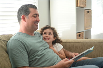 Father reading a book to his daughter