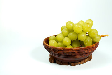 Ripe green grapes spilling out of a rustic wooden bowl, creating a vibrant and healthy image