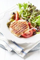 Grilled Turkey Breast with fresh salad. Bright background.	