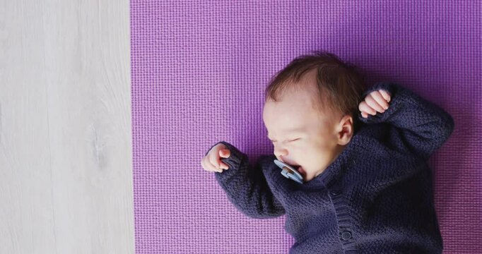 Video of caucasian newborn baby sleeping on violet blanket