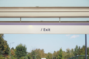 Clear exit sign at public transportation station in daylight