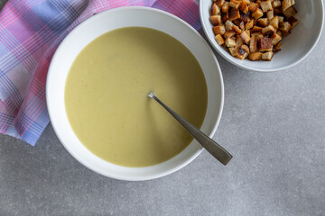 creamy leek soup with toasted bread cubes on grey countertop
