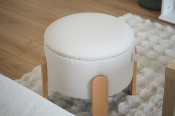 Modern ottoman with wooden legs in a cozy living room