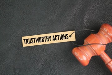 Judge's gavel and paper tag with the words trustworthy actions