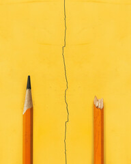 Conceptual representation of division portrayed through broken and intact pencils against a vibrant yellow background. Generative AI