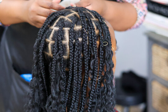Black woman having her hair braided
