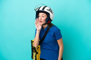 Young caucasian woman with thermal backpack isolated on white background shouting with mouth wide open to the lateral