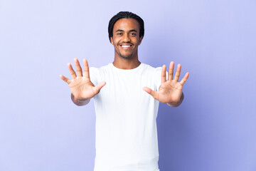 Fototapeta premium Young African American man with braids man isolated on purple background counting ten with fingers