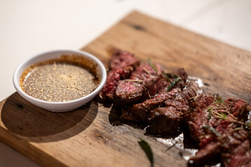 Medium rare sliced fried meat on wooden plate