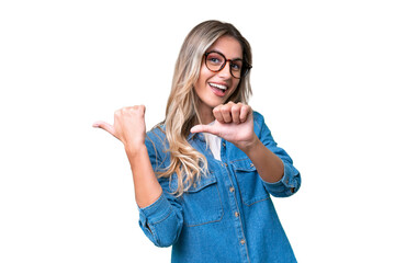 Young Uruguayan woman over isolated background pointing to the side to present a product