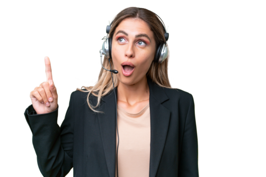 Telemarketer pretty Uruguayan woman working with a headset over isolated background thinking an idea pointing the finger up