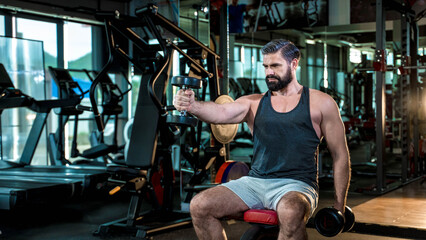 Determined mature man working out with dumbbells in gym, focusing on strength training and muscle building for healthy active lifestyle and fitness goals