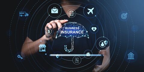Business insurance concept with icons and umbrella hologram hovering above tablet in hand on dark background with digital blue circular interface.