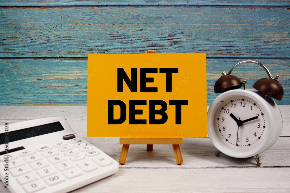 Poster net debt text written on paper card with calculator and alarm clock on wooden background