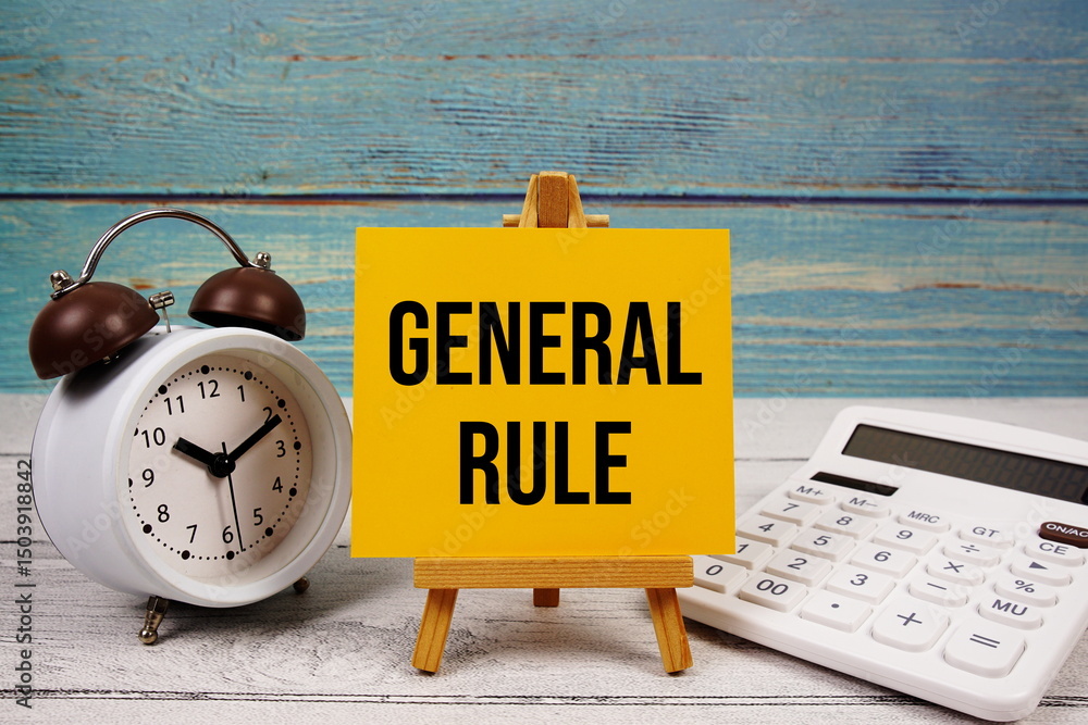 Poster general rule text written on paper card with calculator and alarm clock on wooden background