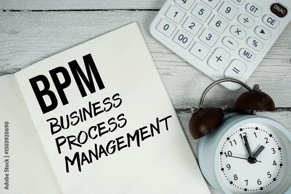 Poster bpm business process management text on paper notebook page with alarm clock and calculator on woode