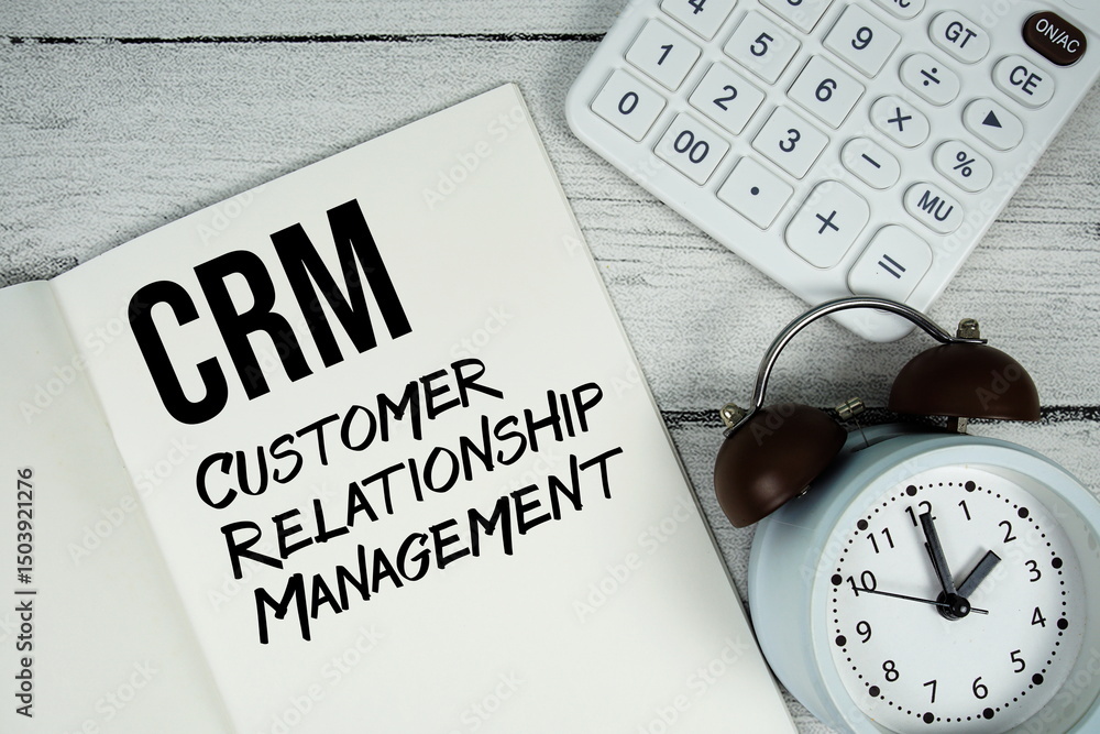 Aufkleber crm customer relationship management text on paper notebook page with alarm clock and calculator on 