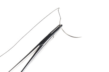 Close-up of a surgical needle threaded with non-absorbable suture. Sharp point and fine thread against a white background.