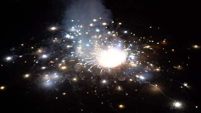 Spinning fire cracker zameen chakri spinner on the ground throwing sparks all around showing one of the ways to celebrate the hindu festival Diwali