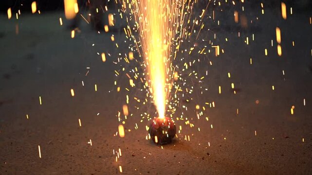Low slow motion shot of clay flower pot fire cracker with golden sparks coming out and shooting into the air showing the celebrations during the hindu festival of light Diwali